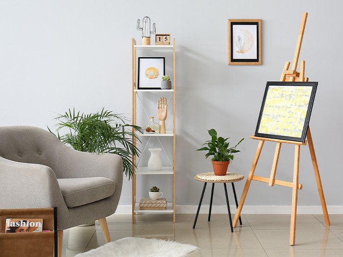 accent chair with small bookshelf and easel with painting